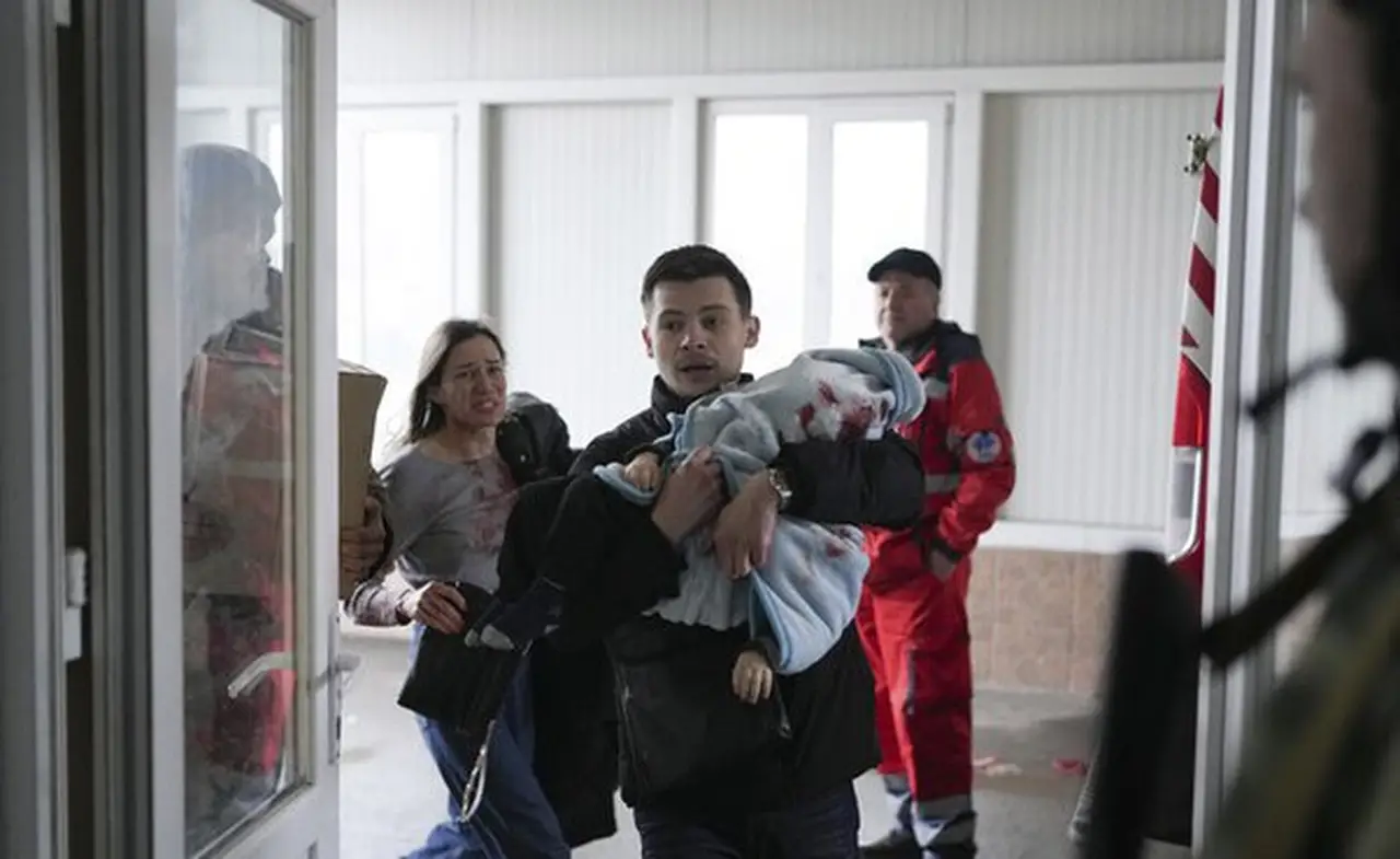 Um pai carrega seu filho morto em um bombardeio em Mariupol Foto AP